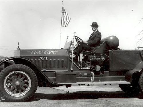 Old firefighters riding on automobile